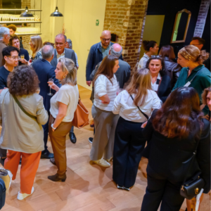 illustration de la soirée de rentrée 2025 par une photographie de 2024 avec un groupe de personne qui discutent en buvant du champagne